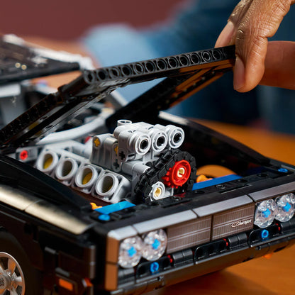 Three-quarter overhead view of the built black LEGO Technic 42231 Dodge Charger R/T muscle car model showing its chrome engine intake and wide rubber racing tires.