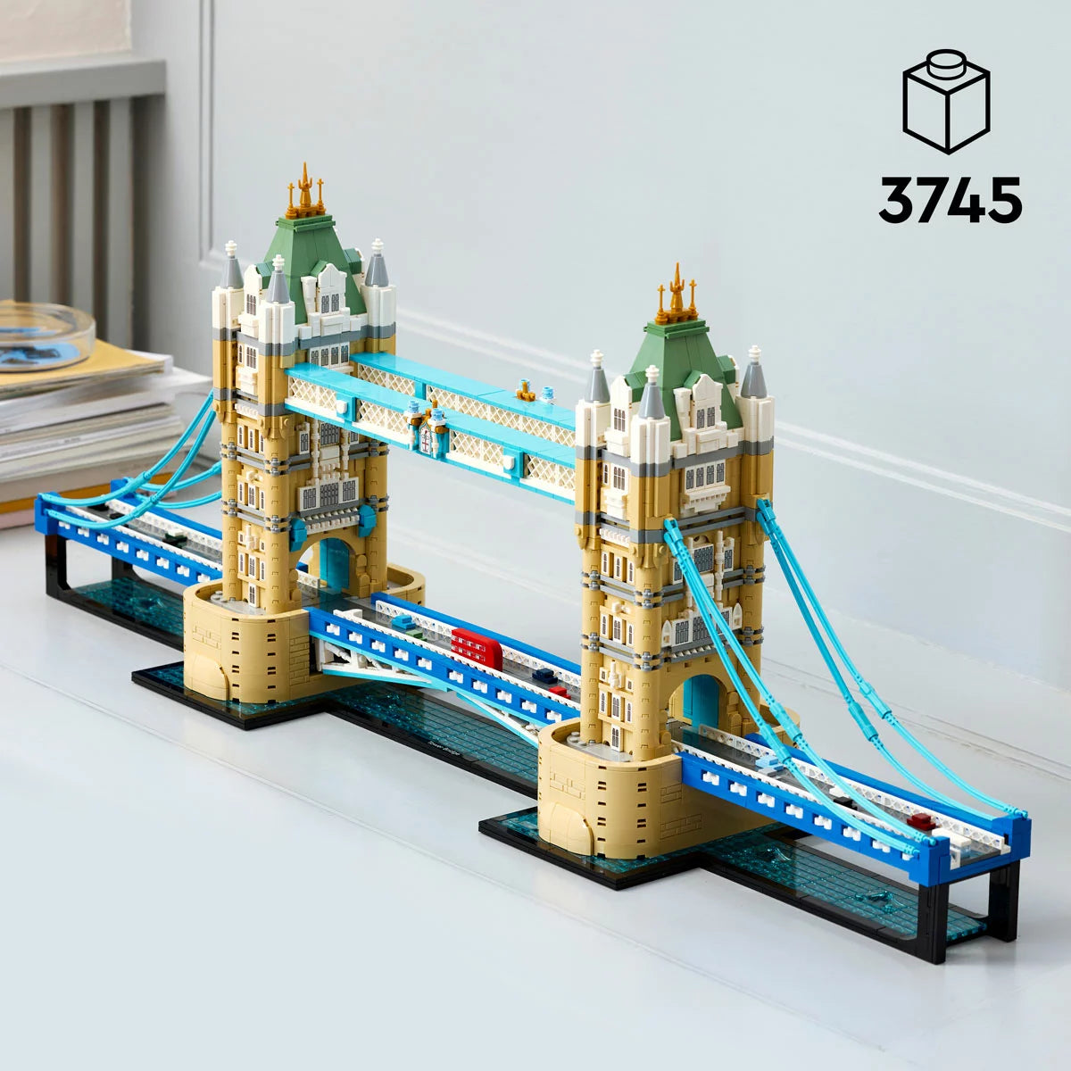 Front angle view of the assembled LEGO Architecture Tower Bridge 21067 set featuring blue suspension cables, raised central bascules, and microscale buses on the base.