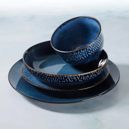 The Laurie Gates Catalina 16-Piece Reactive Stoneware Dinnerware Set arranged neatly on a table, showcasing its artisanal reactive glaze finish and complete place settings.