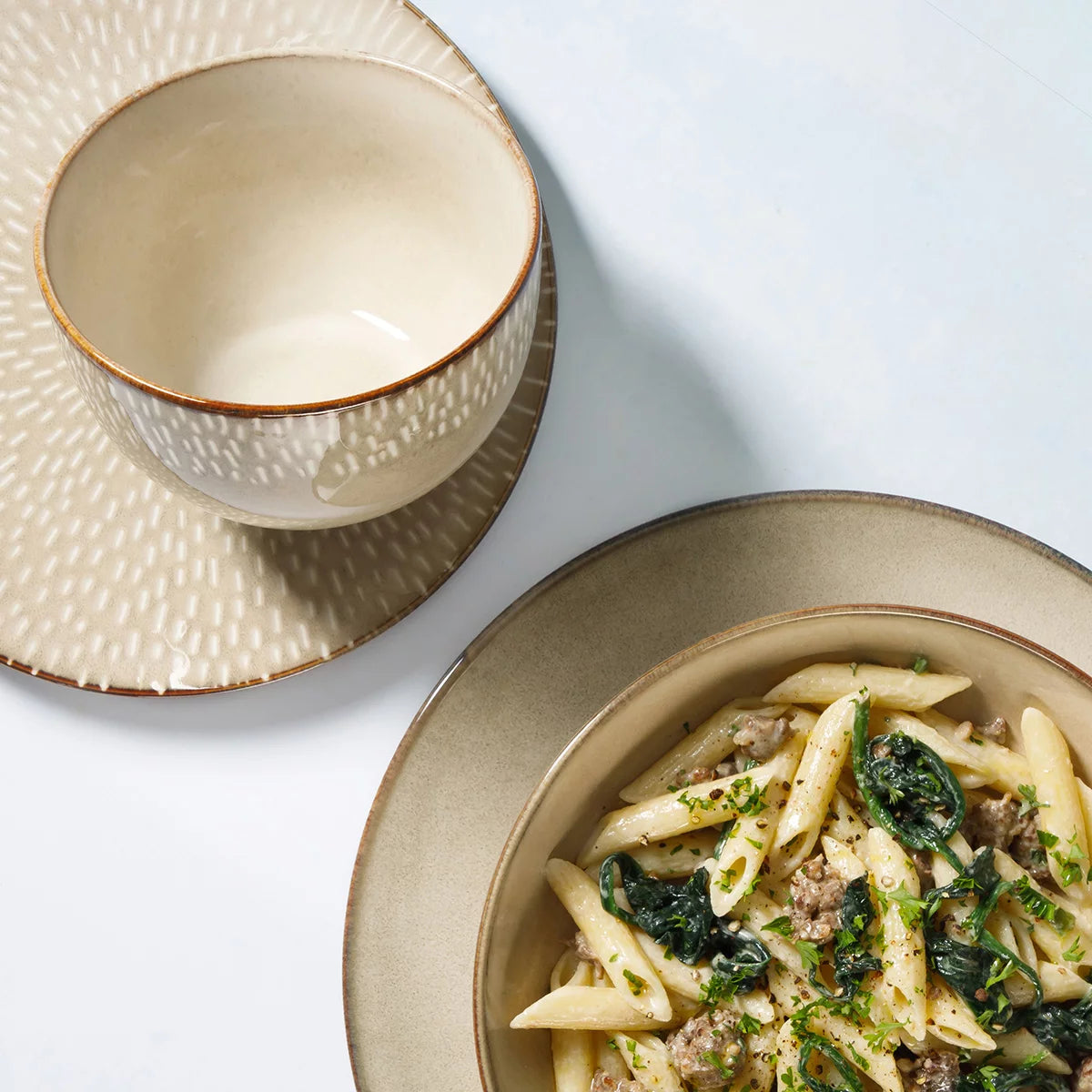 The Laurie Gates Catalina 16-Piece Reactive Stoneware Dinnerware Set arranged neatly on a table, showcasing its artisanal reactive glaze finish and complete place settings.