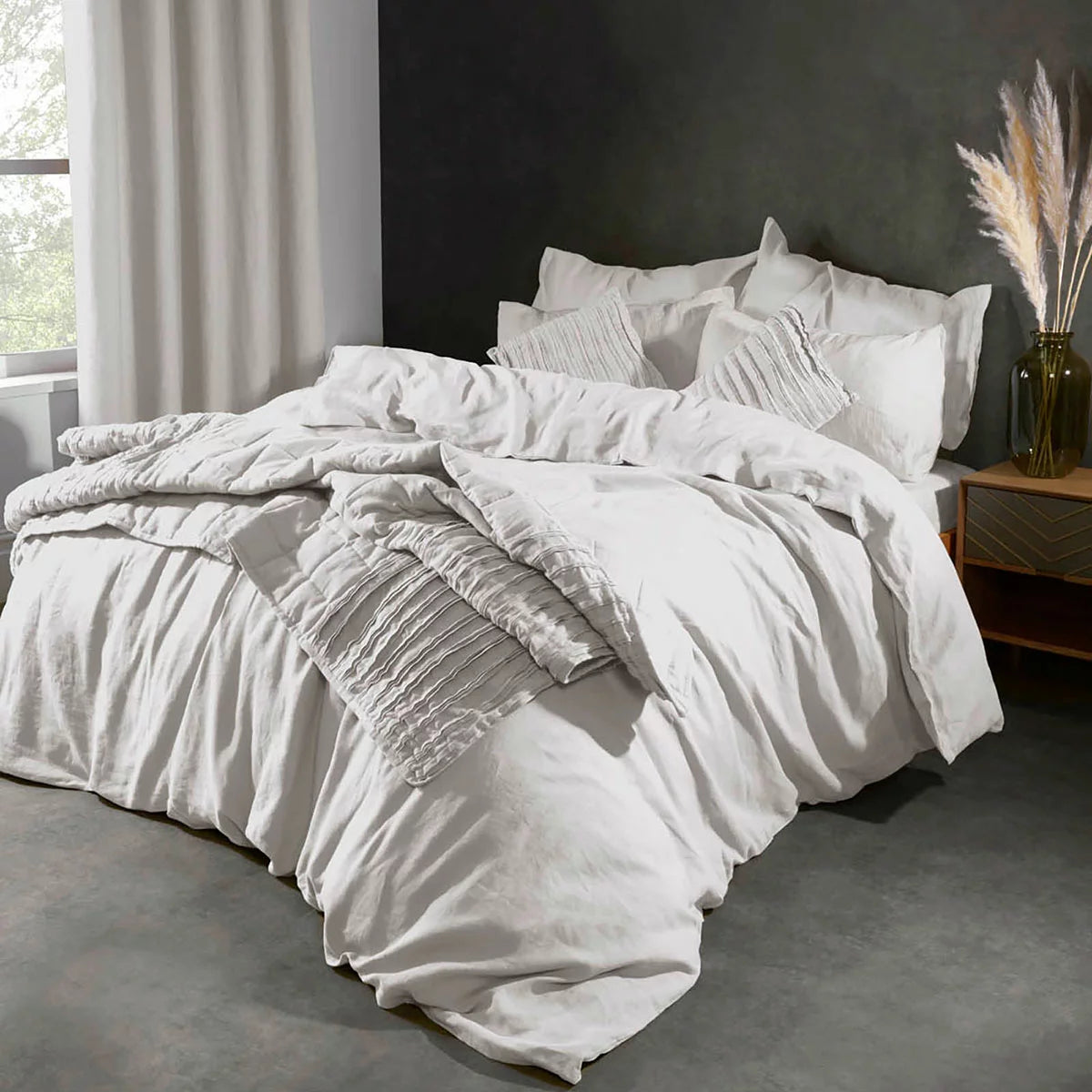 Top-down view of the Lazy Linen 100% washed white linen duvet cover set dressed on a king-size mattress with crisp, textured matching pillowcases in a sunlit bedroom.