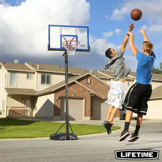 Black and red Lifetime 48 inch portable basketball hoop with clear shatter-proof backboard set up on a paved outdoor driveway.