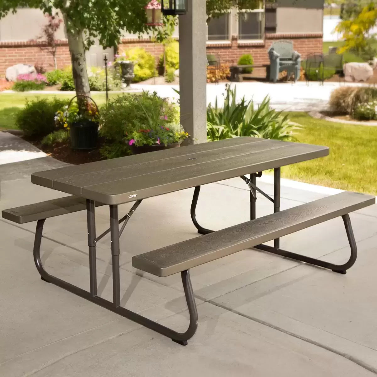 Lifetime 6ft Classic Folding Picnic Table in Putty color with a steel frame on a green backyard lawn.