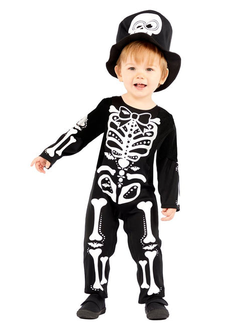 Front view of a toddler wearing the black and white Lil Skeleton Suit jumpsuit featuring a printed bow tie and matching dapper skull top hat against a light neutral background.