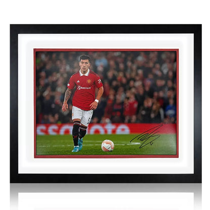 A premium wooden-framed action photograph of Lisandro Martínez in a Manchester United kit, displayed against a neutral background with a metal plaque.