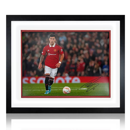 A premium wooden-framed action photograph of Lisandro Martínez in a Manchester United kit, displayed against a neutral background with a metal plaque.