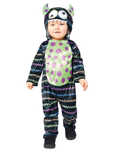 Front view of a child wearing a soft blue and orange Little Monster Costume jumpsuit with an attached character face hood in a cozy living room setting.