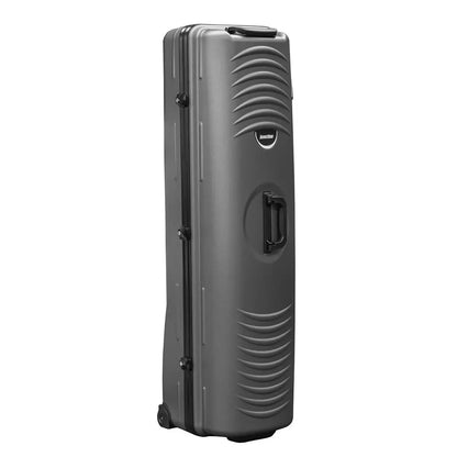 Side angle view of the black Longridge Hard Case Golf Travel Cover standing upright on a smooth terminal floor, showing the rigid ABS plastic shell, integrated roller wheels, and top retractable handle.