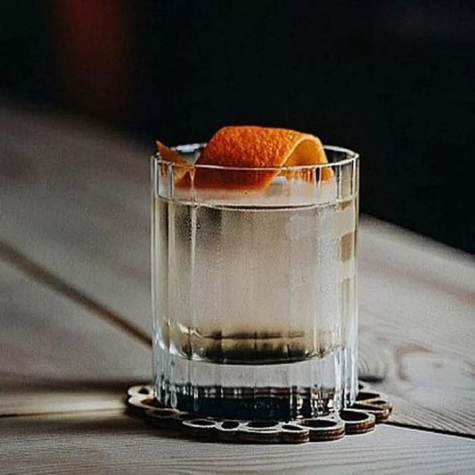 Eight Luigi Bormioli Bach Double Old Fashioned glasses with their signature fluted design, arranged on a home bar, showing their heavy, stable base and crystal clarity.