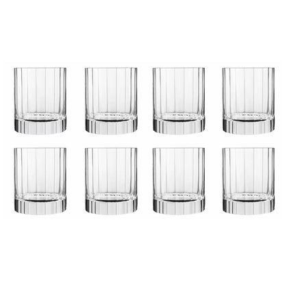 Eight Luigi Bormioli Bach Double Old Fashioned glasses with their signature fluted design, arranged on a home bar, showing their heavy, stable base and crystal clarity.