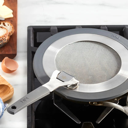 MIU 2-piece stainless steel splatter screen set with foldable silicone handles displayed next to frying pans.