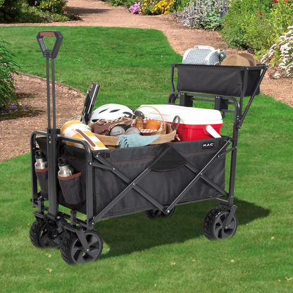 A heavy-duty black Mac Sports Deluxe Folding Wagon stands on a grassy field, highlighting its wide all-terrain wheels, integrated front brakes, and extended telescoping handle.