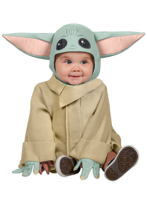 Front view of a toddler wearing the soft tan fleece Mandalorian Grogu robe with attached hand covers and plush big-eared headpiece on a hardwood floor.