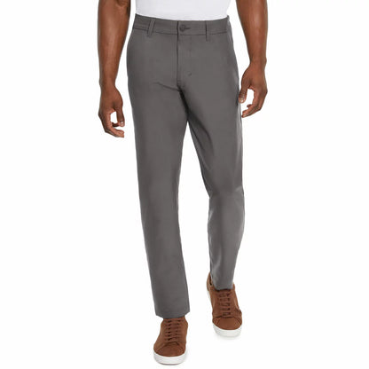 Front view of a model wearing Marc New York men's black commuter pants paired with clean sneakers in a modern studio setting.