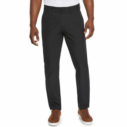 Front view of a model wearing Marc New York men's black commuter pants paired with clean sneakers in a modern studio setting.