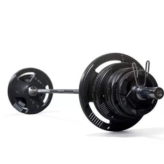 A heavy-duty Marcy 140kg Olympic weight set featuring black triple-grip cast iron plates stacked neatly next to a silver 7-foot knurled steel barbell with chrome spring collars on a black rubber gym floor.
