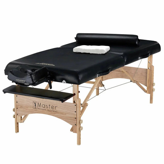 The Master Massage Gibraltar 81cm table fully set up with a bolster and face cradle in a professional treatment room, highlighting the rich wood grain and premium upholstery.