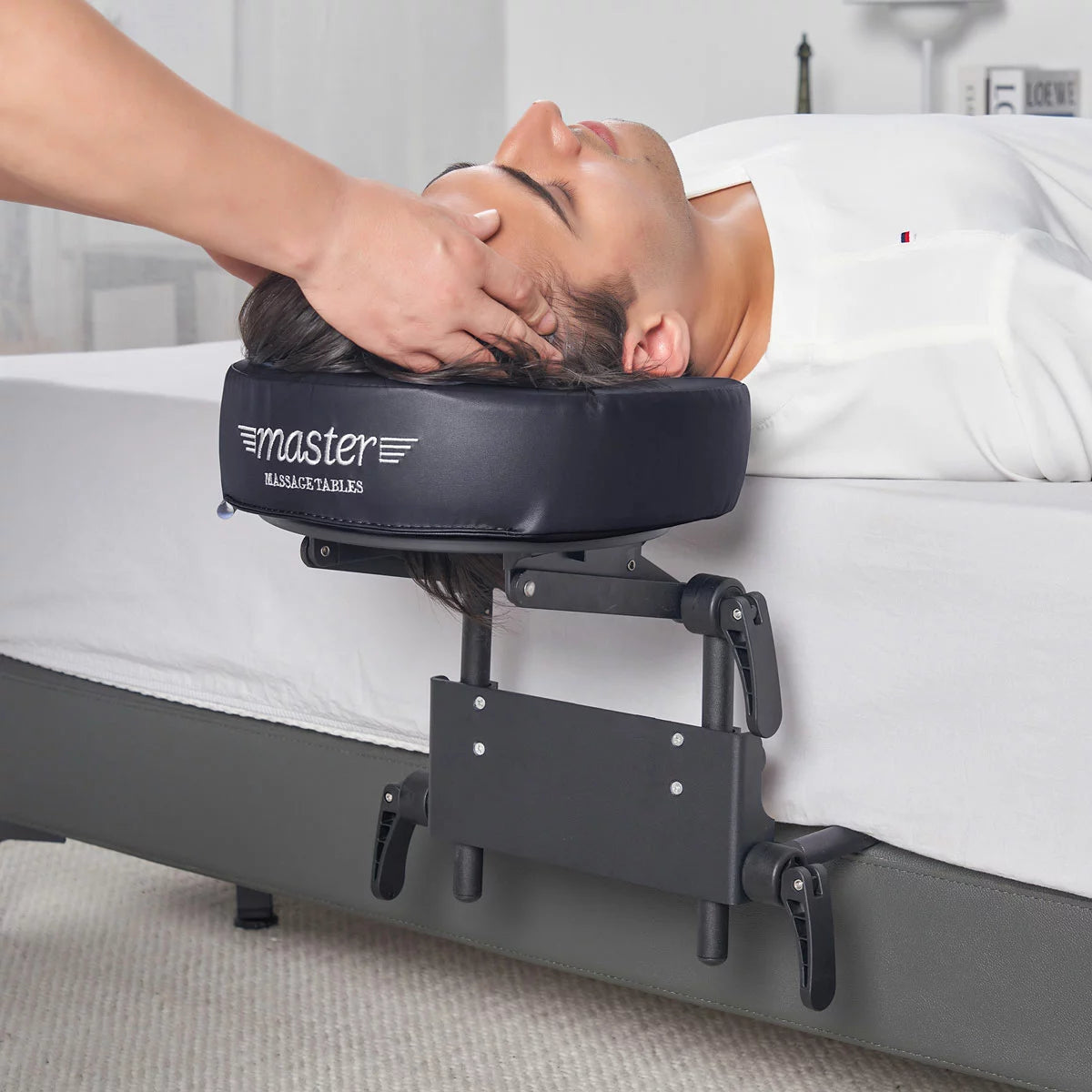 The Master Massage Mattress Top Kit set up on a bed, showing the adjustable face cradle, comfort pillow, and the aluminum frame structure.
