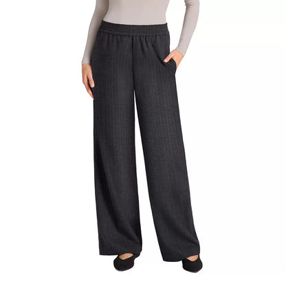 Front view of a woman wearing black Matty M high-rise pinstripe wide-leg pants paired with modern footwear in a bright studio setting.