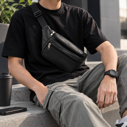 Front angle view of a men's brown premium leather crossbody bag with adjustable shoulder strap resting on a wooden surface.