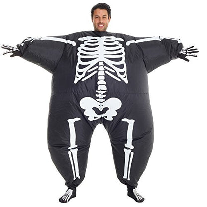 Front view of a man wearing the inflated Morph black and white skeleton MegaMorph costume standing in a brightly lit party setting.