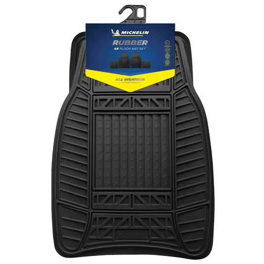 Angled eye-level shot of a four-piece set of black Michelin heavy-duty rubber car mats showing deep tread patterns and non-slip cleated backings on a clean studio surface.