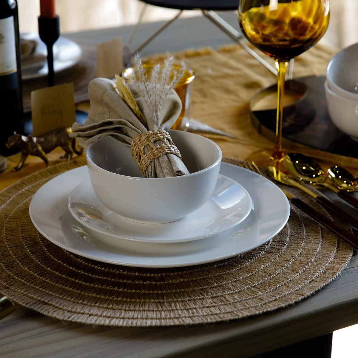 The Mikasa Alexis 12-Piece Porcelain Dinnerware Set neatly arranged on a table, highlighting its clean white finish and modern coupe-style plates and bowls.
