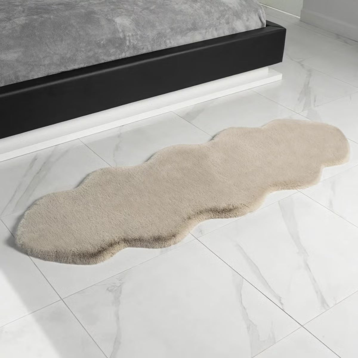 Overhead close-up shot of the plush 37mm high-density pile of the ivory Mon Chateau faux fur twin rug resting on a dark wood floor.