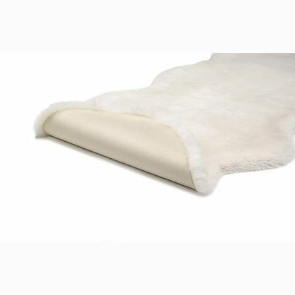 Overhead close-up shot of the plush 37mm high-density pile of the ivory Mon Chateau faux fur twin rug resting on a dark wood floor.