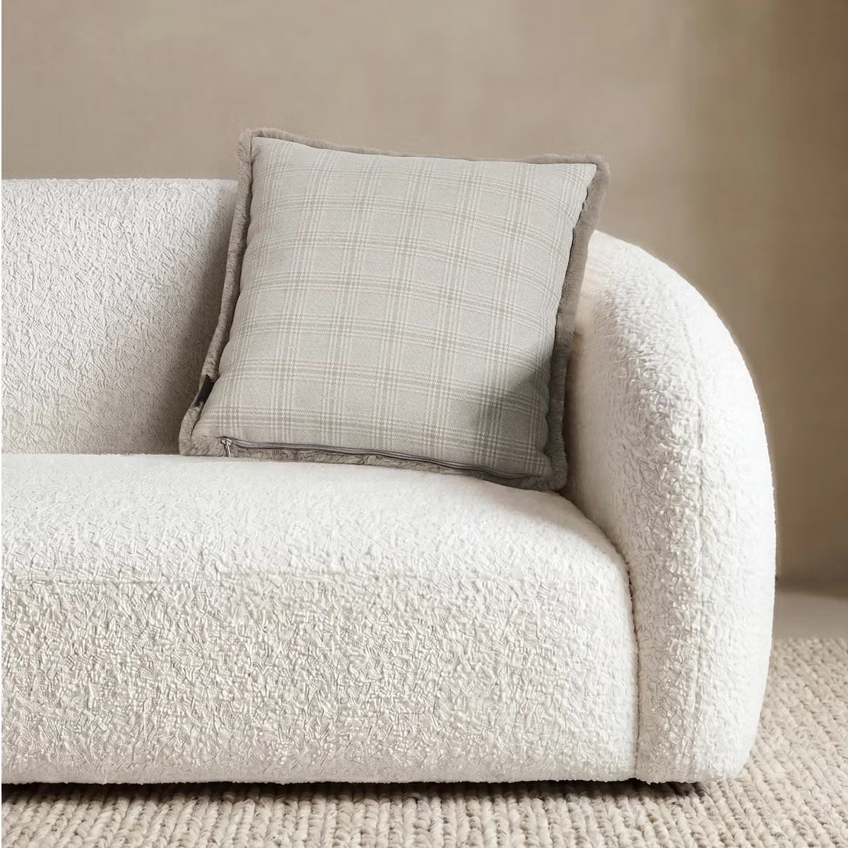 Front view of the 50x50 cm Mon Chateau tweed cushion resting on a sofa, showing its patterned fabric front alongside the plush faux fur edge.