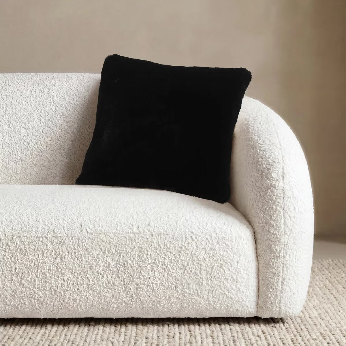 Front view of the 50x50 cm Mon Chateau tweed cushion resting on a sofa, showing its patterned fabric front alongside the plush faux fur edge.