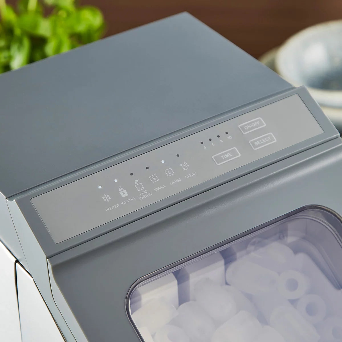 Morphy Richards FrostPro silver bullet ice maker machine on a clean kitchen countertop with clear viewing window showing bullet ice cubes and included scoop.
