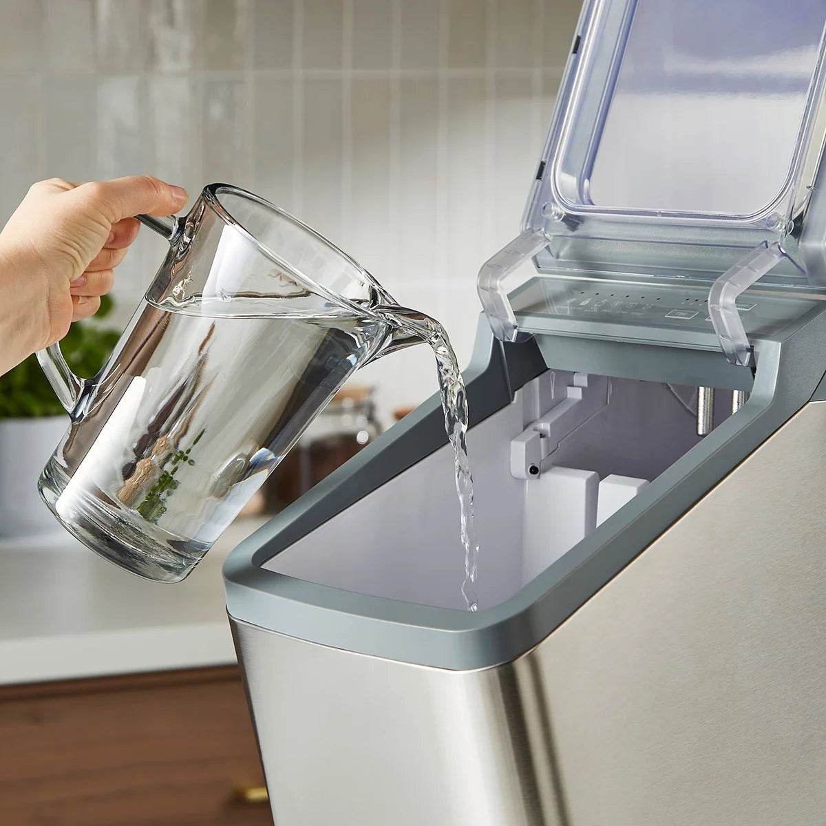Morphy Richards FrostPro silver bullet ice maker machine on a clean kitchen countertop with clear viewing window showing bullet ice cubes and included scoop.