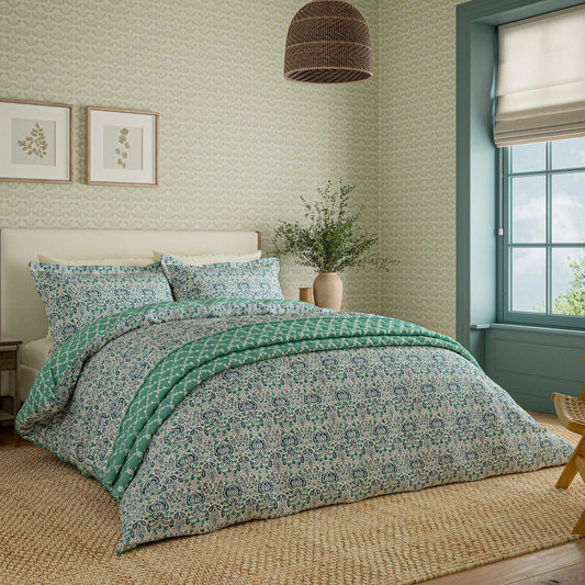 Front view of the Morris and Co Little Chintz cotton duvet cover set displaying the detailed pomegranate pattern on a neatly made bed in a brightly lit bedroom.