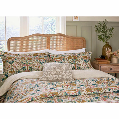 A wide angled shot of the Morris and Co Lodden Primrose duvet cover set outspread on a master bed highlighting the detailed interlocking yellow and beige floral patterns.