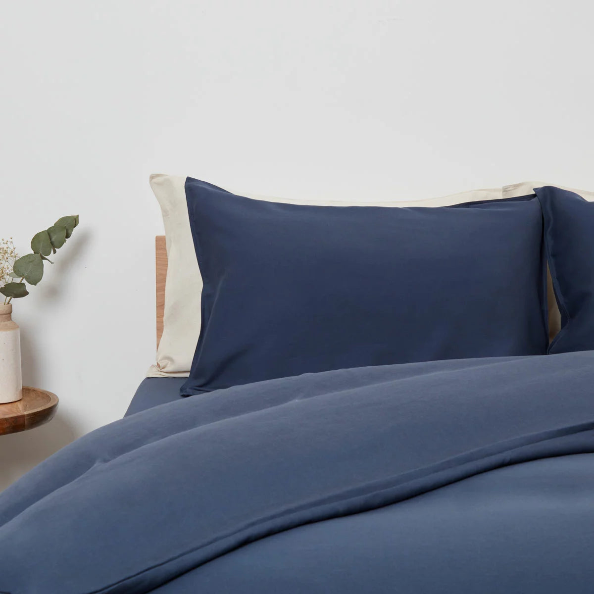 Panda Navy Bamboo and French Linen Duvet Cover Set on a bed featuring crisp matte texture, Oxford pillowcase edges, and raw bamboo buttons.