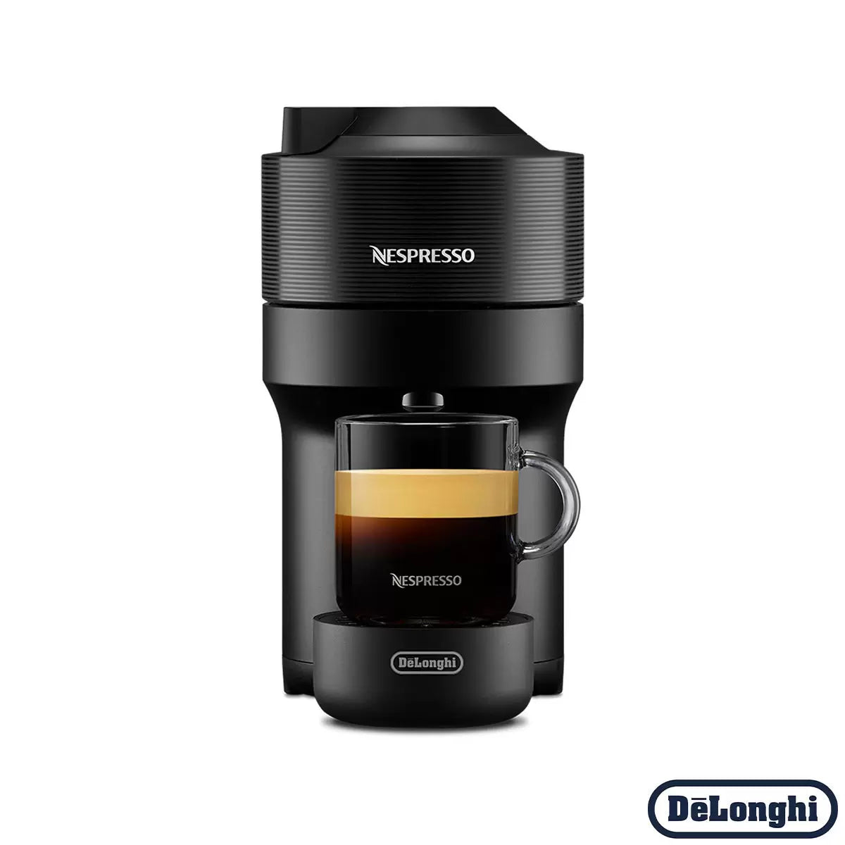 Front view of the matte black De'Longhi Nespresso Vertuo Pop coffee machine on a kitchen counter with a glass mug filled with layered coffee and rich foam.