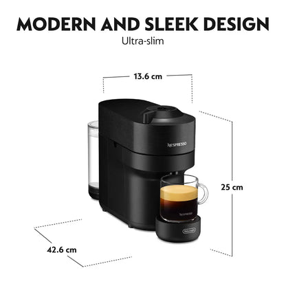 Front view of the matte black De'Longhi Nespresso Vertuo Pop coffee machine on a kitchen counter with a glass mug filled with layered coffee and rich foam.