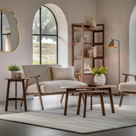 Front three-quarter view of the Gallery Neyland natural linen 2-seater sofa, showcasing its light-wash solid ash wood frame and soft textured natural cream linen cushions in a minimalist living room.