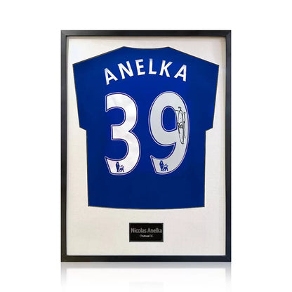 A professionally framed official Chelsea football shirt signed by Nicolas Anelka, displayed with a crisp white mount inside a sleek, high-quality wooden frame.