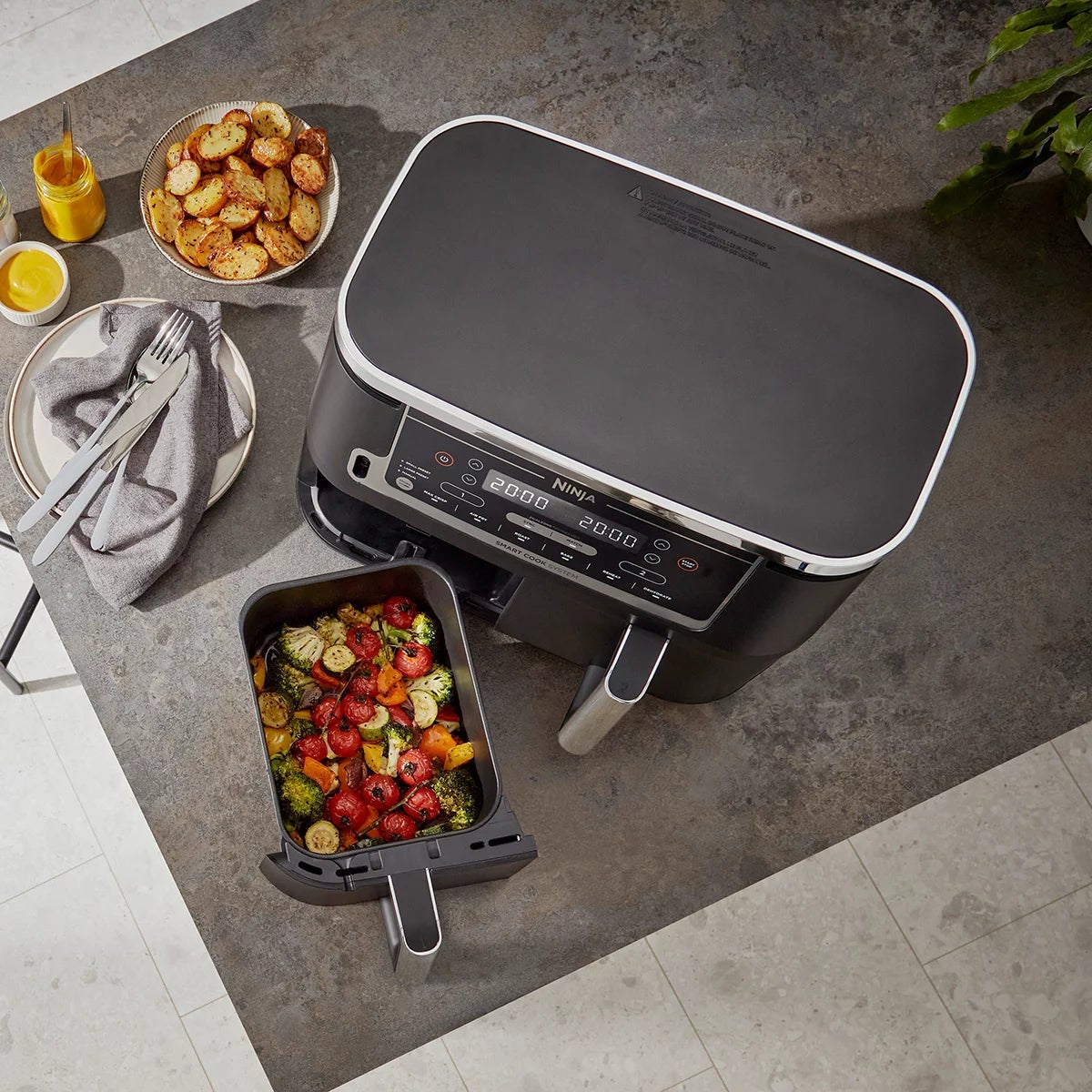 Front angle view of the black Ninja Foodi MAX AF451UK Dual Zone Air Fryer with digital touch screen displaying two pulled-out drawers and digital probe.