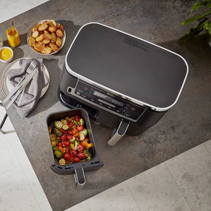 Front angle view of the black Ninja Foodi MAX AF451UK Dual Zone Air Fryer with digital touch screen displaying two pulled-out drawers and digital probe.