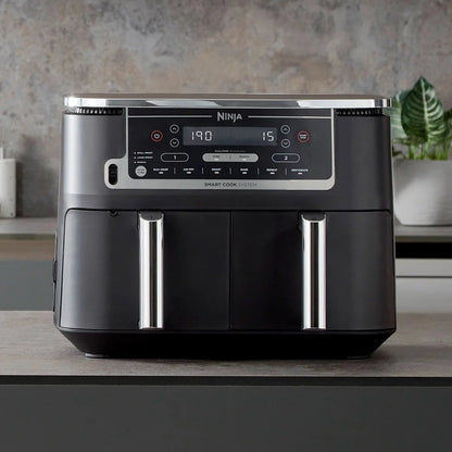 Front angle view of the black Ninja Foodi MAX AF451UK Dual Zone Air Fryer with digital touch screen displaying two pulled-out drawers and digital probe.