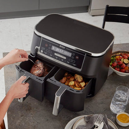 Front angle view of the black Ninja Foodi MAX AF451UK Dual Zone Air Fryer with digital touch screen displaying two pulled-out drawers and digital probe.