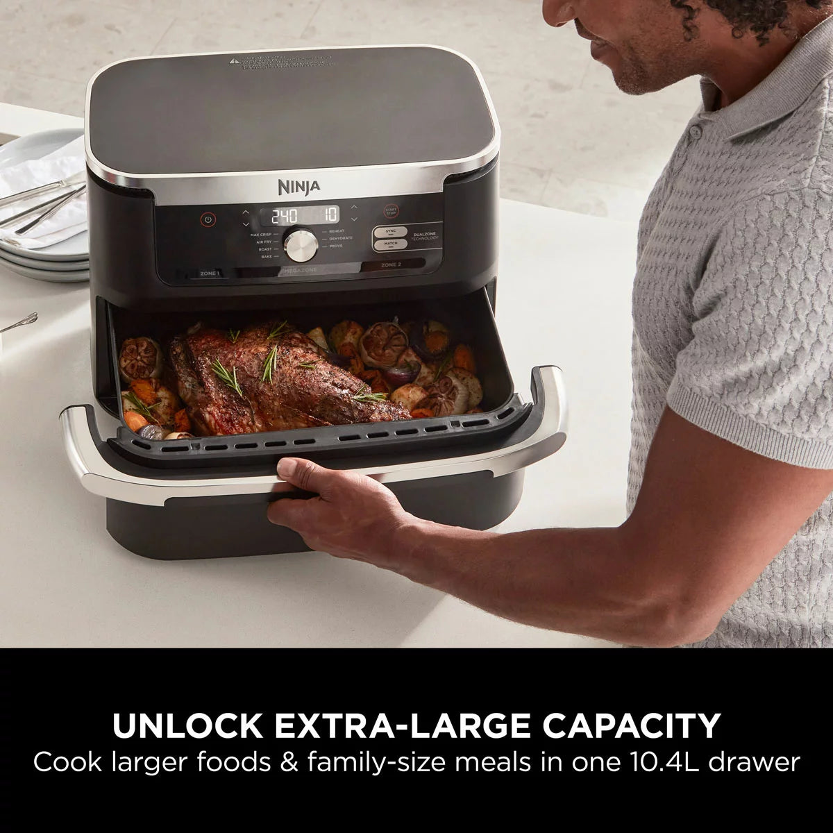 Ninja Foodi FlexDrawer 10.4L air fryer in black, shown with the dual-zone drawer pulled open to reveal the interior on a clean, modern kitchen countertop.