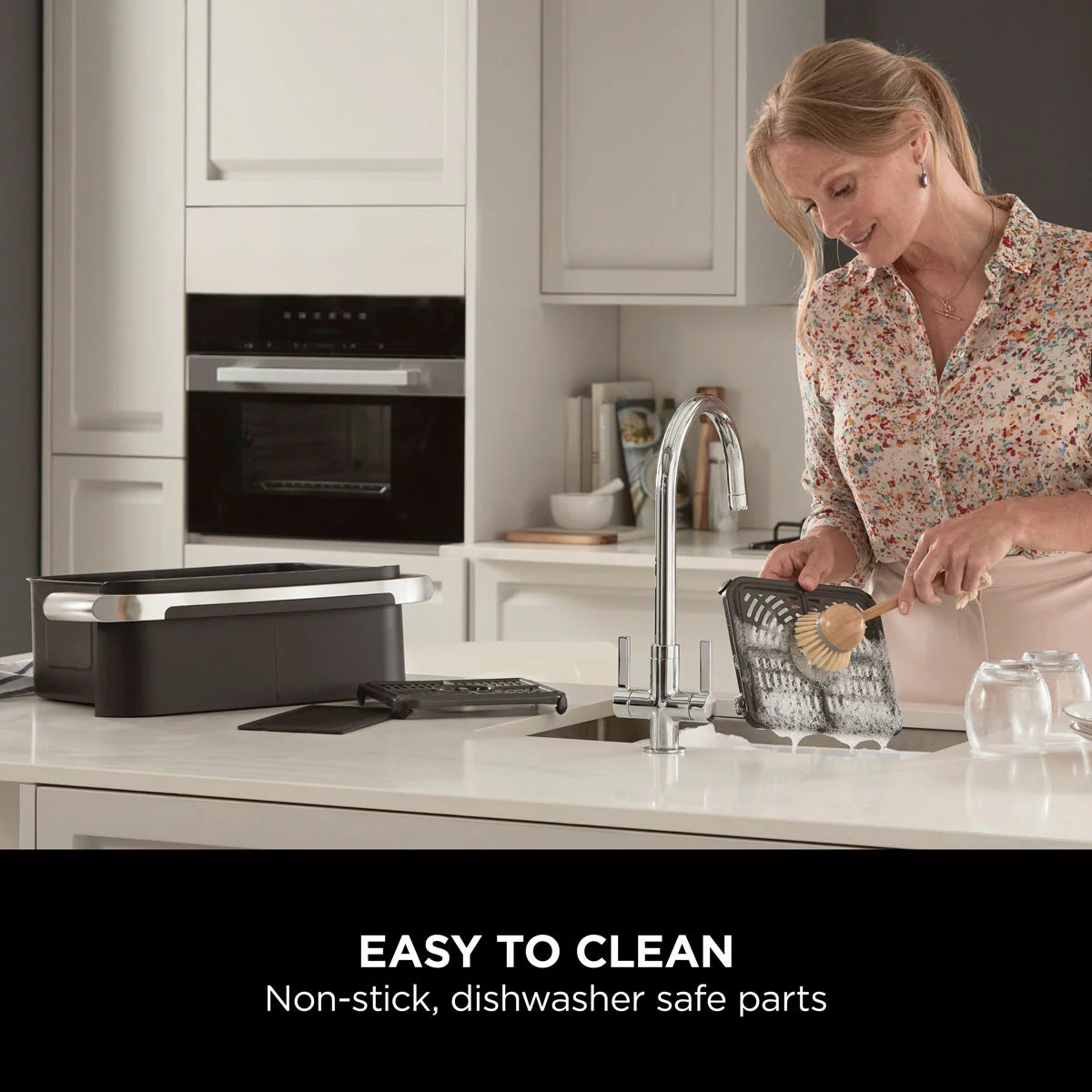 Ninja Foodi FlexDrawer 10.4L air fryer in black, shown with the dual-zone drawer pulled open to reveal the interior on a clean, modern kitchen countertop.
