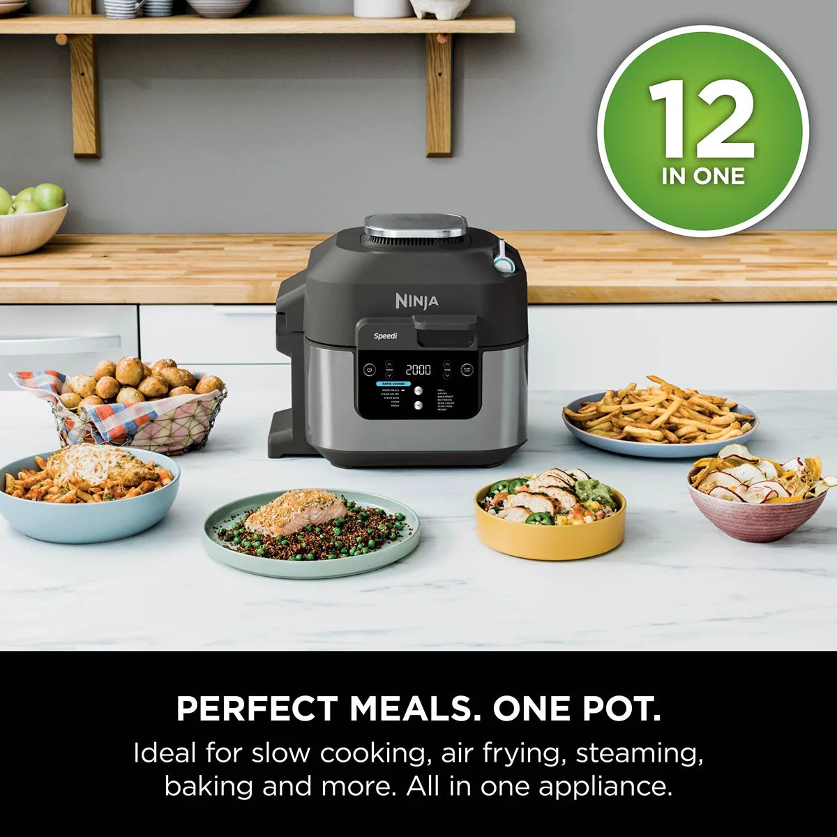Front view of the black steel Ninja Speedi ON500UK multi cooker sitting on a dark kitchen countertop with its lid open, displaying cooked chicken breasts and steamed vegetables inside the inner pot.