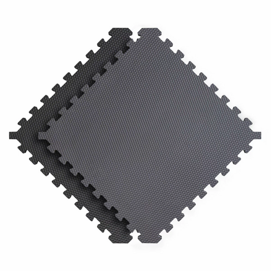 Top-angle view of six interlocking 20mm thick grey and black Norsk reversible foam tiles laid out on a concrete home gym floor.