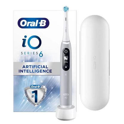 Oral-B iO Series 6 electric toothbrush in grey, displayed next to a travel case and a fresh Ultimate Clean brush head on a clean white surface.