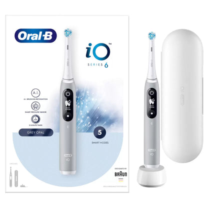Oral-B iO Series 6 electric toothbrush in grey, displayed next to a travel case and a fresh Ultimate Clean brush head on a clean white surface.